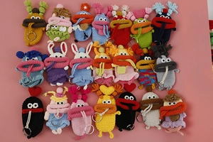 Detailed overhead view of multiple handmade crochet monster key covers in various colors