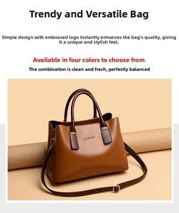Close-up of brown leather tote bag with metallic logo and adjustable shoulder strap