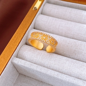 Macro detail of 24K gold plated flower ring with sparkling zircon inlays and lace texture