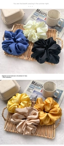 Macro shot of assorted satin silk scrunchies in various colors on a decorative tray