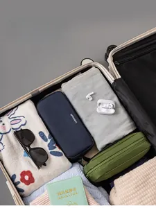 Detail of navy and olive travel organizer bags for electronics inside a suitcase
