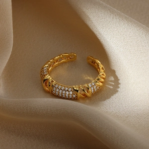 Macro detail of gold devil eye ring with micro-set zircon on champagne silk fabric