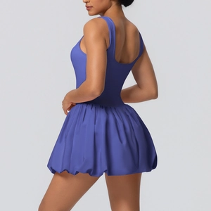 Detail view of the open-back design and pleated skirt of this navy blue tennis dress