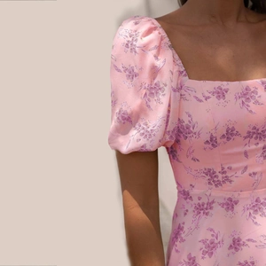 Detail of pink floral puff sleeves and square neckline on a slim fit summer dress