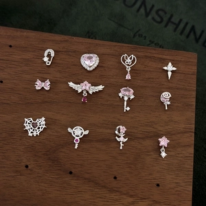 Pink heart and star bow earrings with zircons displayed on a dark wood stand