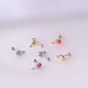 Set of 6 titanium steel tragus earrings with colorful gems on a soft pink background