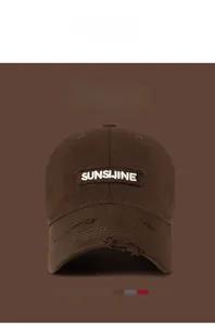 Detailed view of frayed brim and SUNSHINE embroidery on brown vintage baseball cap