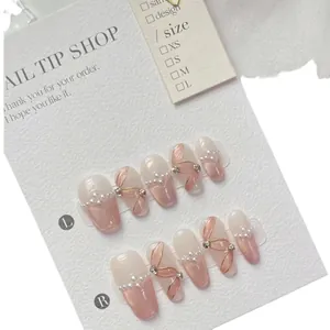 Handmade ballet press-on nails with pearl bows and cat eye glitter in pink gradient