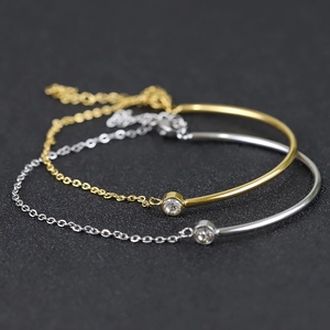 Close-up of minimalist 18K gold and silver plated chain bracelets with zircon inlay