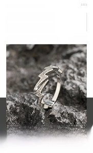 Macro shot of silver lightning ring with inlaid zircons on a dark rock background