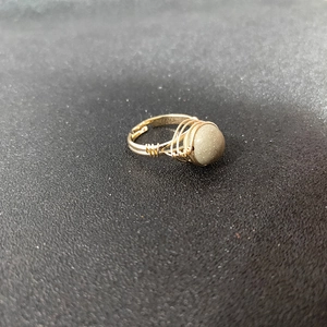 Macro view of handmade gold wire wrapped ring with a grey matte natural stone
