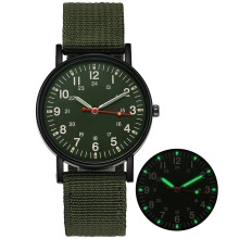 Army style quartz watch with green nylon strap and dial showing luminous glow effect