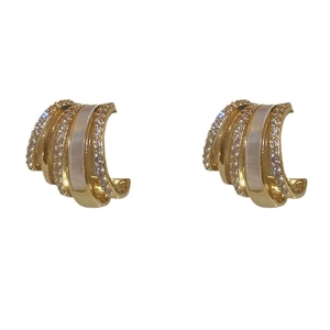 Gold plated C-shaped hoop earrings with zircons and white enamel inlays on white background