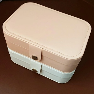 Stack of pink and white PU leather jewelry organizers with metal snap buttons