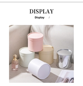 Stack of five colorful mini cylindrical gift boxes on a sofa for flower arrangements