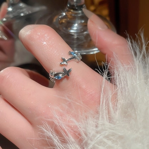 Detail of adjustable silver flower ring featuring blue zircon and butterfly accents