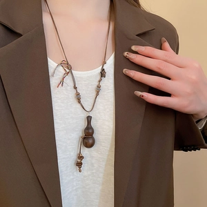 Detail of vintage wooden gourd pendant on a hand-woven ethnic style cord necklace