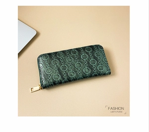 Detail of green embossed leather long wallet with circular pattern and gold zipper