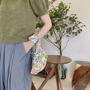 Floral cotton wrist bag shown on model arm with colorful retro flower patterns