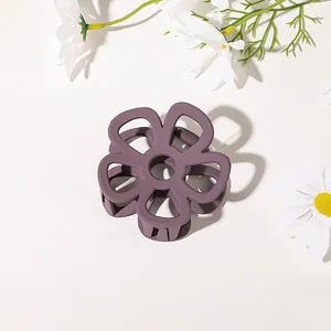 Detailed top view of matte dark purple flower hair claw clip with cutout petal design
