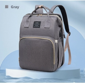 Detailed view of grey diaper bag on white pedestal with USB port and waterproof fabric