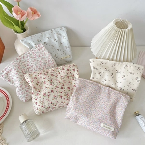 Floral fabric cosmetic bags in various colors styled with tulips and perfume bottles