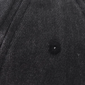 Close-up of ventilation eyelets and washed fabric texture on a black baseball cap
