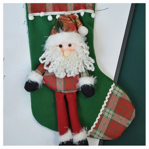 Detail of green velvet Christmas stocking featuring a 3D plush Santa and plaid accents