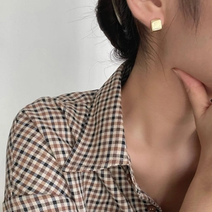 Minimalist square 925 silver stud earrings in gold finish worn on ear lobe