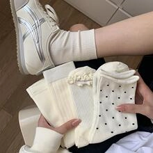 Close-up of cream-colored floral ribbed crew socks with stylish petal details