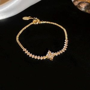 Macro shot of gold-plated clover bracelet with marquise-cut cubic zirconia on black velvet