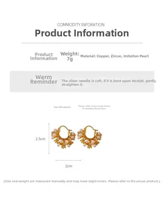Detail view of U-shaped gold earrings with zircons and pearls, 2.5cm x 2cm dimension