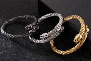 Vue détaillée des bracelets en fil d'acier noir, argent et or avec têtes de mort