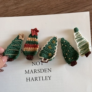 Detail of handmade crochet Christmas tree hair clips with fine wool yarn textures