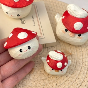 Detail shot of hand-carved mushroom figurine with cute face and red polka dot cap