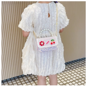 Détail du sac à paillettes pour enfants avec poignée en perles et broderie cerise