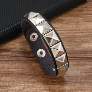 Detail of black faux leather bracelet with silver square pyramid studs and snap closure