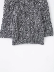Detail of grey cable knit texture and ribbed hem on a stylish short sleeve cardigan