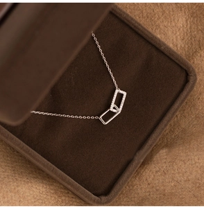Dettaglio di pendenti rettangolari intrecciati su collana in argento in scatola regalo