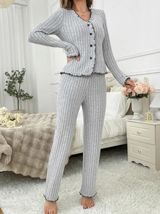 Detail of grey ribbed pajama set featuring black wave trim and V-neck buttoned cardigan