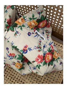 Macro detail of floral canvas tote bag with red roses and Merci label tag