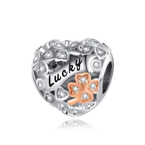 Macro detail of heart charm with Lucky engraving and rose gold clover accent