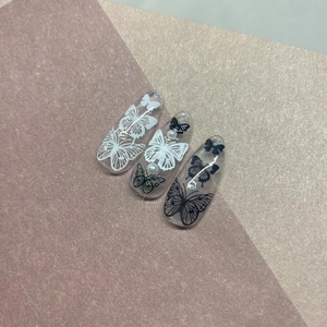 Elegant press-on nails with 5D black butterfly designs, pearls and rhinestones on clear base