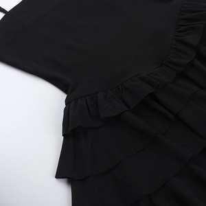 Detailed macro view of black ruffle layers and chiffon fabric texture on sexy backless dress