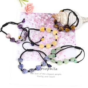 Detailed shot of handmade woven heart agate crystal bracelets in diverse natural stones