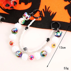 Halloween beaded keychain with skull and eyeball charms on an orange festive background