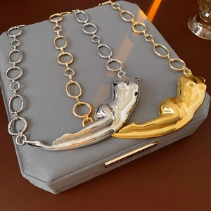 Détail des pendentifs léopard en or et argent avec chaîne à gros maillons ronds