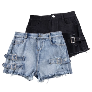 Close-up of denim shorts featuring metal buckles and frayed edges in blue and black