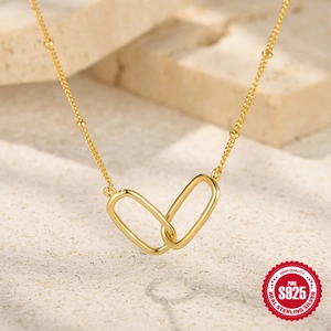 Detailed macro view of S925 sterling silver interlocking double ring pendant in gold finish
