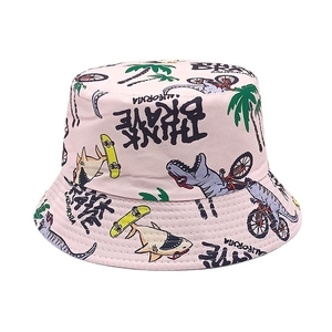 Detailed view of kids sun hat with colorful dinosaur and shark prints on pink canvas